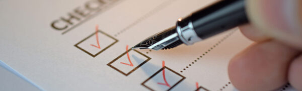 Checklist concept - checklist box with red checkmark, paper and a pen with checklist word on table